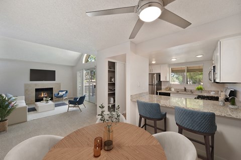 a living room and dining room with a table and chairs